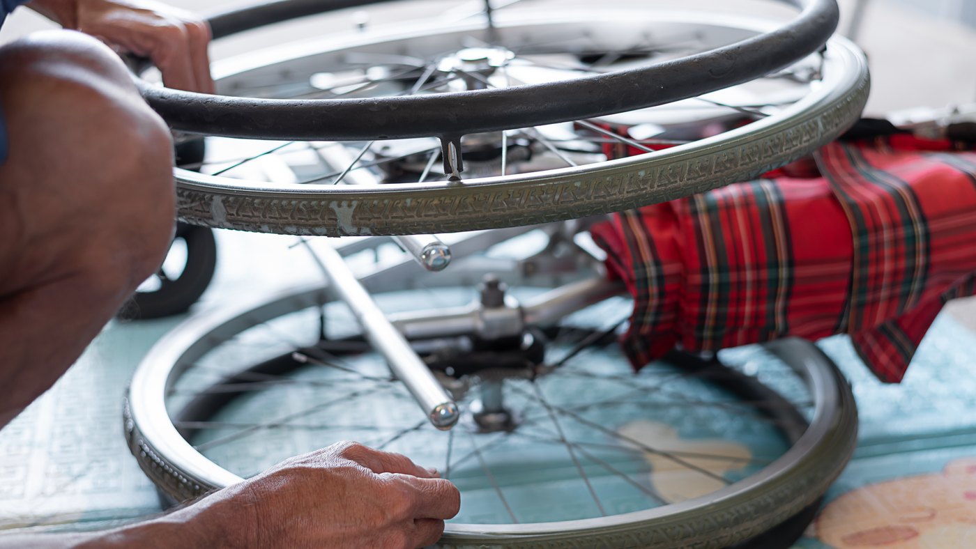 Técnico ajusta la rueda de una silla de ruedas durante su mantenimiento